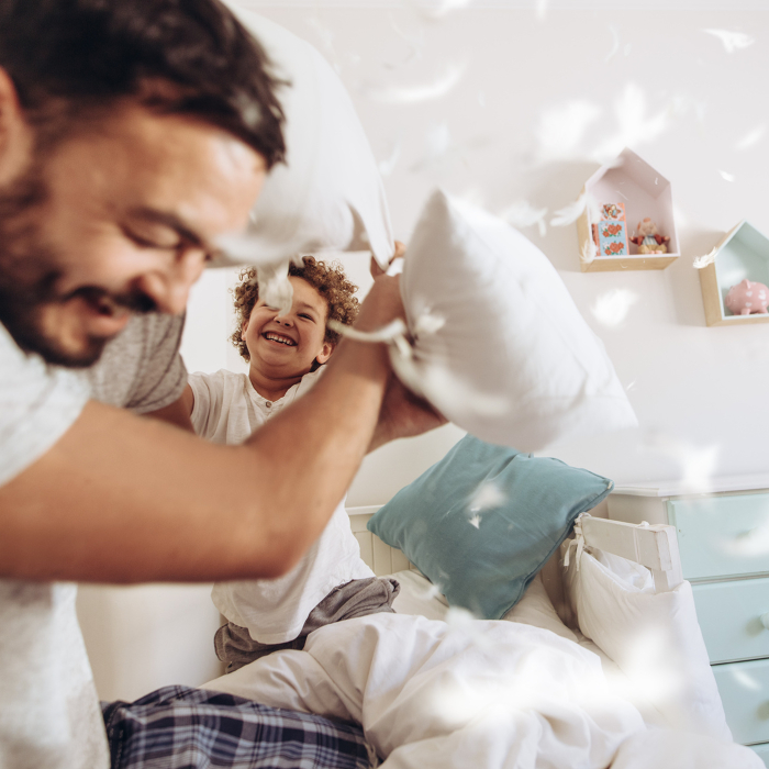 Kissenschlacht im Kinderzimmer mit Papa und Sohn.