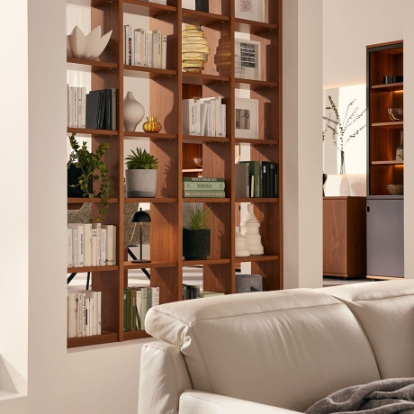 Ledersofa und elegantes Holzregal als Raumteiler von Musterring