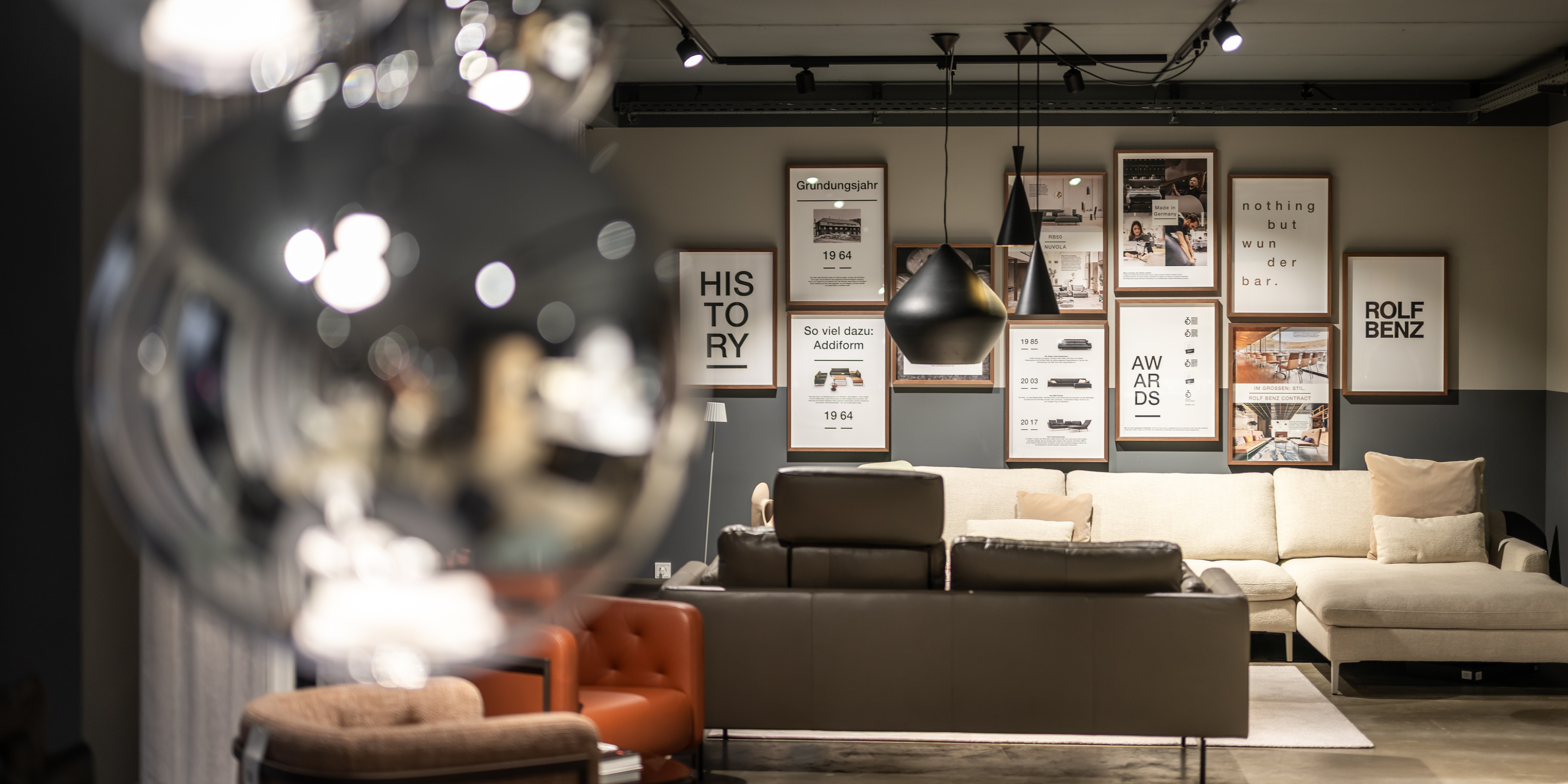 Aufnahme im Rolf Benz Haus Allgäu mit heller Sofalandschaft und Fotowand.