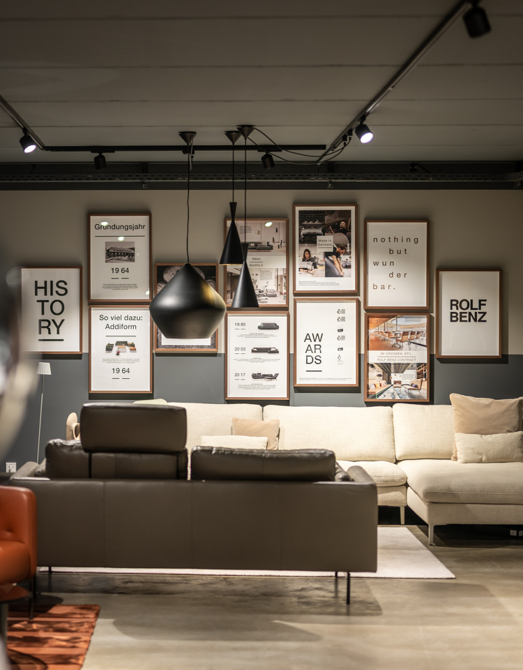 Aufnahme im Rolf Benz Haus Allgäu mit heller Sofalandschaft und Fotowand.
